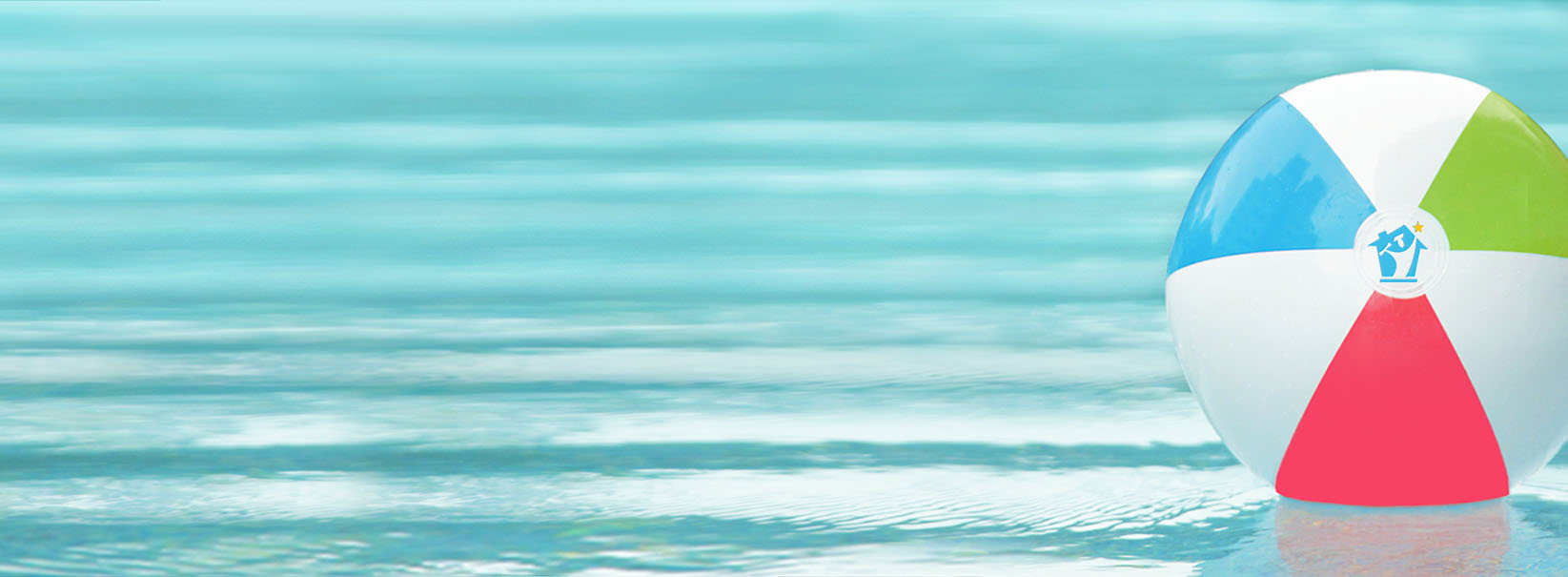Colorful beach ball floating on calm turquoise water.