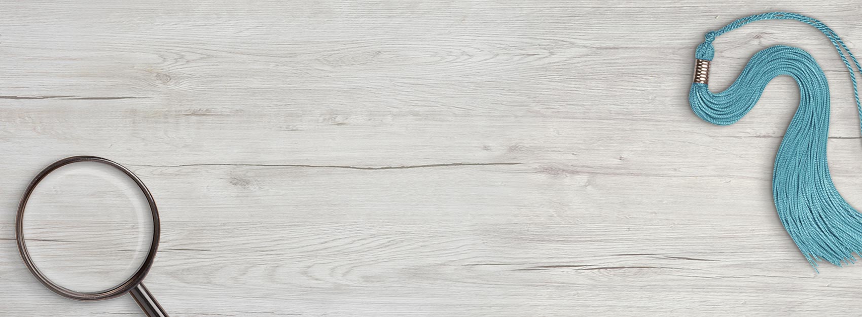 The HomeScholar graphic. A magnifying glass, with a blue graduation tassel placed above the text.